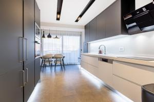 a kitchen with black and white cabinets and a table at Utopia Suites in Burunabat