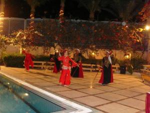 een groep mensen die 's nachts bij een zwembad dansen bij Sea Garden Hotel in Hurghada