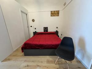 a bedroom with a red bed and a black chair at Spago rooms 2 in Vieste
