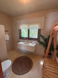 a bathroom with a sink and a window and a toilet at Avra Tatajuba in Tatajuba