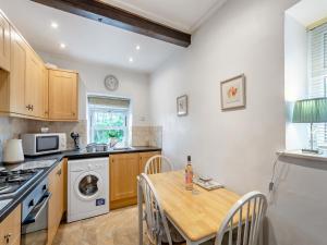 a kitchen with a table and a stove and a microwave at Holme House Cottage in Oakworth