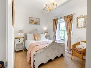 a bedroom with a bed and a chair and a window at Holme House Cottage in Oakworth
