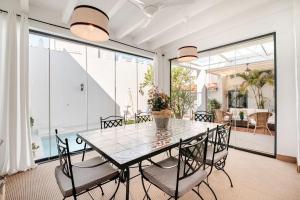 una sala da pranzo con tavolo e sedie in vetro di Casa palacio reformada S.XVIII a Sanlúcar de Barrameda