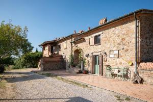 an old stone house with a patio in front of it at Agriturismo TerraMadre in Massa Marittima