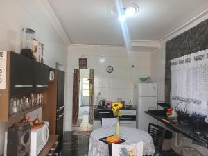 Casa com piscina praia grande Beach House في برايا جراندي: مطبخ مع طاولة عليها مزهرية من الزهور