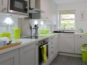 a kitchen with white cabinets and a stove top oven at 11 Elm Court in Keswick
