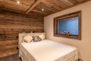a bedroom with a bed and a window at Le Chalet des Serves in Demi-Quartier