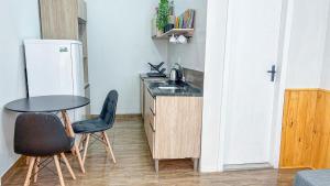 eine kleine Küche mit einem Tisch und zwei Stühlen in der Unterkunft Casa térrea geminada aconchegante AV3402 in Higienópolis