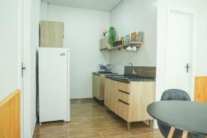 eine Küche mit einem weißen Kühlschrank und einem Tisch in der Unterkunft Casa térrea geminada aconchegante AV3402 in Higienópolis + 11 Fotos