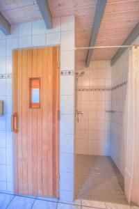 Un baño con ducha y puerta de madera. en Wildgans 48, en Mirow