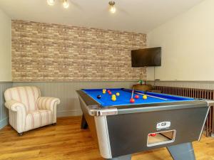 a room with a pool table and a chair at Y Graiglwyd in Amlwch