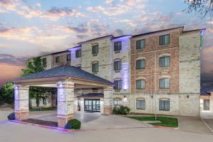 een groot bakstenen gebouw met een prieel aan de voorkant bij Holiday Inn Express and Suites Granbury by IHG in Granbury