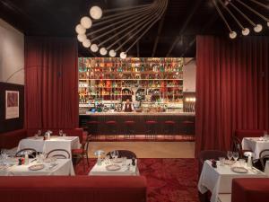 a restaurant with white tables and a bar at Hôtel Saint Christophe Aix en Provence Centre Ville by Germain Collection in Aix-en-Provence