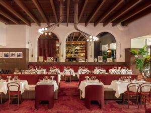 a dining room with white tables and chairs at Hôtel Saint Christophe Aix en Provence Centre Ville in Aix-en-Provence
