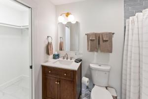 a bathroom with a sink and a toilet and a mirror at Lakeside Retreat in Kingston +36 photos