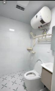 a white bathroom with a toilet and a sink at Aisen BNB National Exhibition Center Hongqiao Shanghai in Shanghai