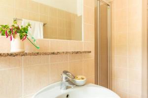a bathroom with a sink and a shower with a mirror at Happy Sea Home - Bilocale Angolo Cottura 4 pax in Albinia +8 photos