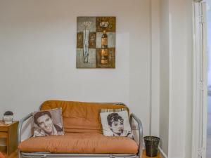 an orange chair in a room with a picture on the wall at Palm Court in Bournemouth