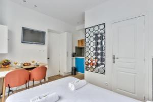 a room with a bed and a table with chairs at Charmant studio au coeur des Batignolles in Paris