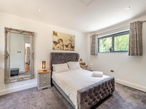 a bedroom with a large bed and a mirror at Foxton Lodge - Uk47296 in Harrietsham +18 photos