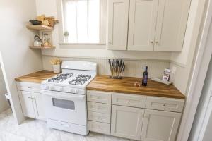 Il comprend une cuisine équipée d'une cuisinière blanche et d'un comptoir. dans l'établissement Cozy Lafayette House Fireplace Parking and Comfort, à Lafayette