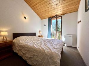 a bedroom with a bed and a large window at Chalet en Duplex 10 Pers. avec Terrasse/Jardin, Proche Pistes – La Salle les Alpes - FR-1-330F-3 in La Salle Les Alpes
