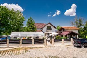 ein Haus mit einem Zaun und einem Auto vor dem Haus in der Unterkunft Къща за гости Фамилия Бешкови in Vratsa