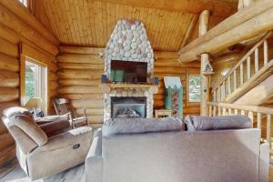 Una sala de estar con chimenea en una cabaña de troncos en Mogul Hill Cabin, en Sandpoint