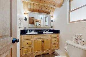 a bathroom with two sinks and a mirror at Mogul Hill Cabin in Sandpoint +45 photos
