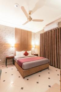 a bedroom with a bed and a ceiling fan at Shelton Rezidor Jinnah Super in Islamabad