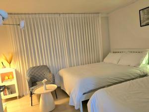 a bedroom with a bed and a chair next to a window at Rinn Stay - Bongcheon Station, Seoul National Uni, Airport Bus in Seoul