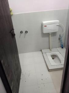 a dirty bathroom with a toilet in a stall at Radhey Krishna Paying Guest House in Ayodhya