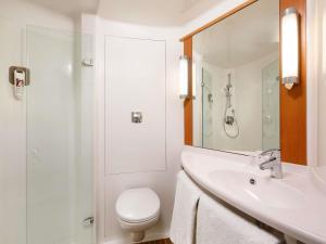 a bathroom with a sink and a toilet and a mirror at ibis Beauvais Aéroport in Beauvais +47 photos