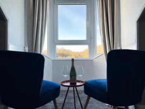a bottle of wine sitting on a table in front of a window at Riverside Cottage in Larkhall