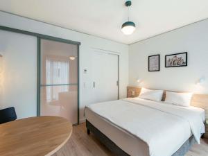 une chambre avec un grand lit et une table dans l'établissement Aparthotel Adagio Muenchen City, à Munich