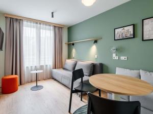 a living room with a table and a couch at Aparthotel Adagio Muenchen City in Munich +66 photos