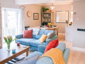 Una sala de estar con un sofá azul y una mesa. en Swallows Nest, en Windermere