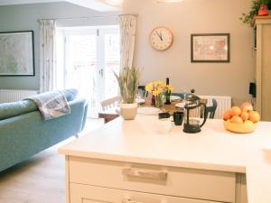cocina y sala de estar con mesa y reloj en Swallows Nest, en Windermere 18 fotos más