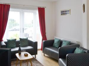 un soggiorno con due divani e un tavolo di Dolphin Cottage a Newbiggin-by-the-Sea