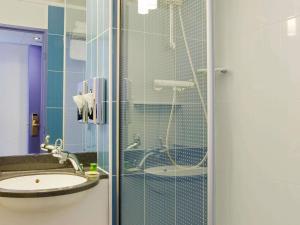 a bathroom with a glass shower with a sink at ibis Styles Fontenay in Fontenay-sous-Bois +32 photos