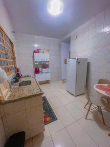 a kitchen with a sink and a refrigerator at Casa de Frente com Maria in Aparecida +14 photos