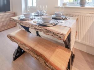 a table with plates and wine glasses on it at Forest Acorn in Brockenhurst