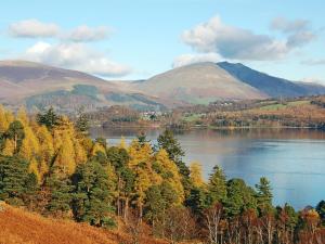 a view of a lake with trees and mountains at The Coach House in Thirlmere