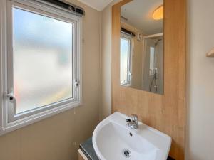 a bathroom with a sink and a window at Peppy in Newton Stewart +3 photos