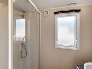 a bathroom with a shower and a window at Peppy in Newton Stewart