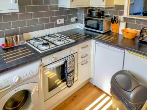 a kitchen with a stove and a washing machine at Riverside Mews in Bideford
