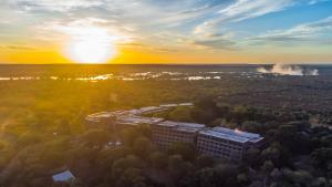 una vista aérea de un edificio con la puesta de sol en el fondo en Elephant Hills Resort, en Victoria Falls