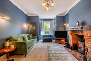 a living room with a couch and a fireplace at Oak View - Norfolk in Fakenham