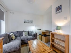 ein Wohnzimmer mit Sofa und Tisch in der Unterkunft Arthurs Den - Cottage in Brixham
