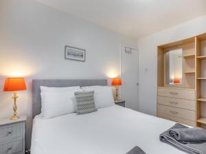 ein Schlafzimmer mit einem großen weißen Bett und zwei Lampen in der Unterkunft Arthurs Den - Cottage in Brixham + 5 Fotos